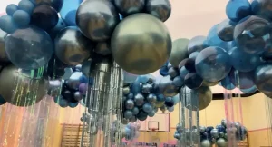Chmura z balonów na studniówce w sali gimnastycznej, efekt dekoracji z kurtynami foliowymi
