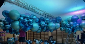 Balonowa dekoracja sali gimnastycznej na studniówkę, chmura balonów z kurtynami foliowymi