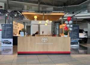 Kiście balonów z helem w kolorach czerwonym i srebrnym ustawione przy recepcji w salonie Toyota Czajka