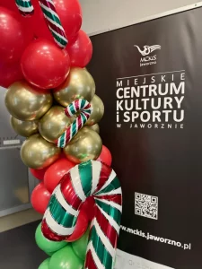 Łuk z balonów w kolorach czerwonym, białym i zielonym z laskami cukrowymi.