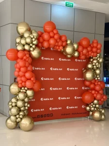 Duże złote balony kule z helem w nowoczesnym wnętrzu.