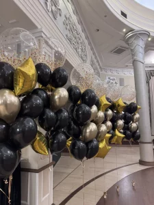 Eleganckie bukiety z helem, w tym duże przezroczyste kule ze złotym konfetti i foliowe gwiazdy, przygotowane dla 7 Technikum z Sosnowca.