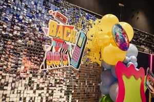 Profesjonalna ścianka balonowa w stylu lat 90. wykonana przez balonowedekoracje.pl dla firmy Amazon w MCK Katowice