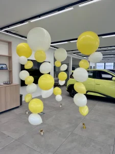 Cztery kolumny balonowe z helem przy aucie pokazowym BYD – realizacja dla firm w Łodzi.