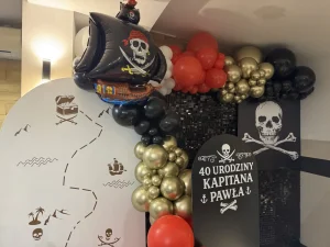 Czarna cekinowa ścianka z piracką flagą z czaszką jako tło do zdjęć