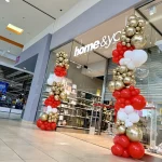 ustrzany połysk balonów złotych chrome w asymetrycznej kompozycji balonowej na otwarcie sklepu.