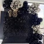 Dekoracja z balonów na osiemnaste urodziny w Świętochłowicach, asymetryczna girlanda balonowa w kolorach czarnym i złotym chromie na tle sali restauracyjnej.