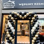 Prostokątna brama balonowa w kolorach czarnym, białym i złotym chrome przed lokalem Stara Wędzarnia w Siemianowicach Śląskich.