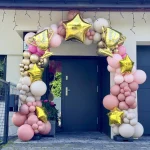 Zjawiskowa, organiczna brama balonowa w odcieniach różu, beżu i złotego chromu, zamontowana przed domem w Mysłowicach z okazji mistrzostwa świata.