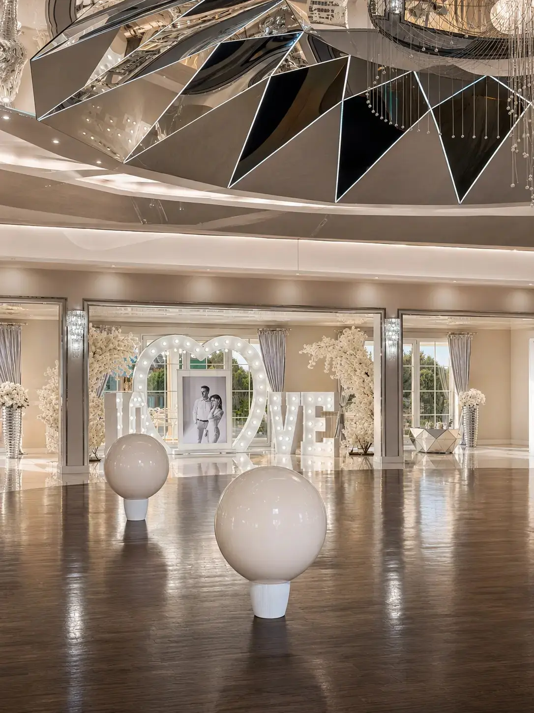 Białe wybuchające balony na wesele o średnicy 90 cm zawieszone pod sufitem eleganckiej sali weselnej