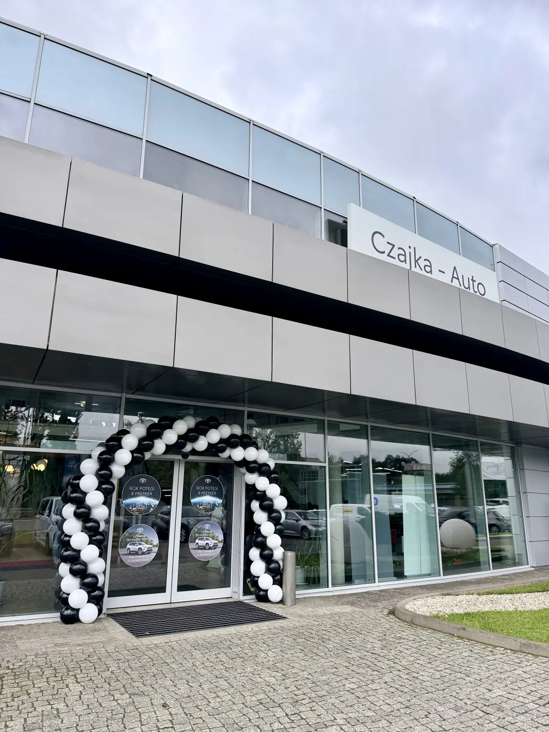 Czarno-biała brama balonowa przed wejściem do salonu Toyota Auto Czajka w Chorzowie