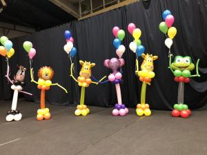 balonowe zoo - zwierzaki z balonów trzymające w jednej ręce kiść z balonów z helem