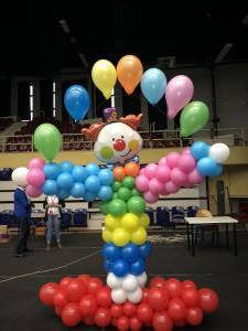 clown z balonów trzymający balony napełnione helem